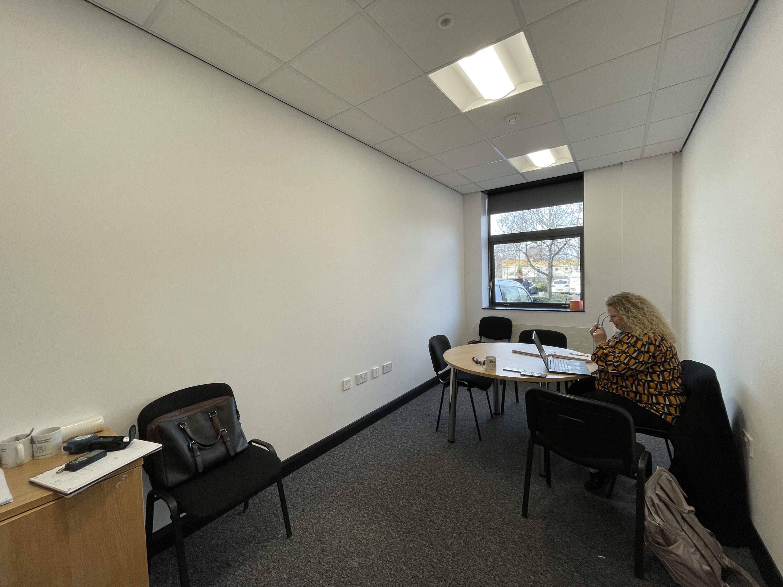 A meeting room at Doncaster Chamber before the refresh, dimly lit with a small table and mismatched chairs