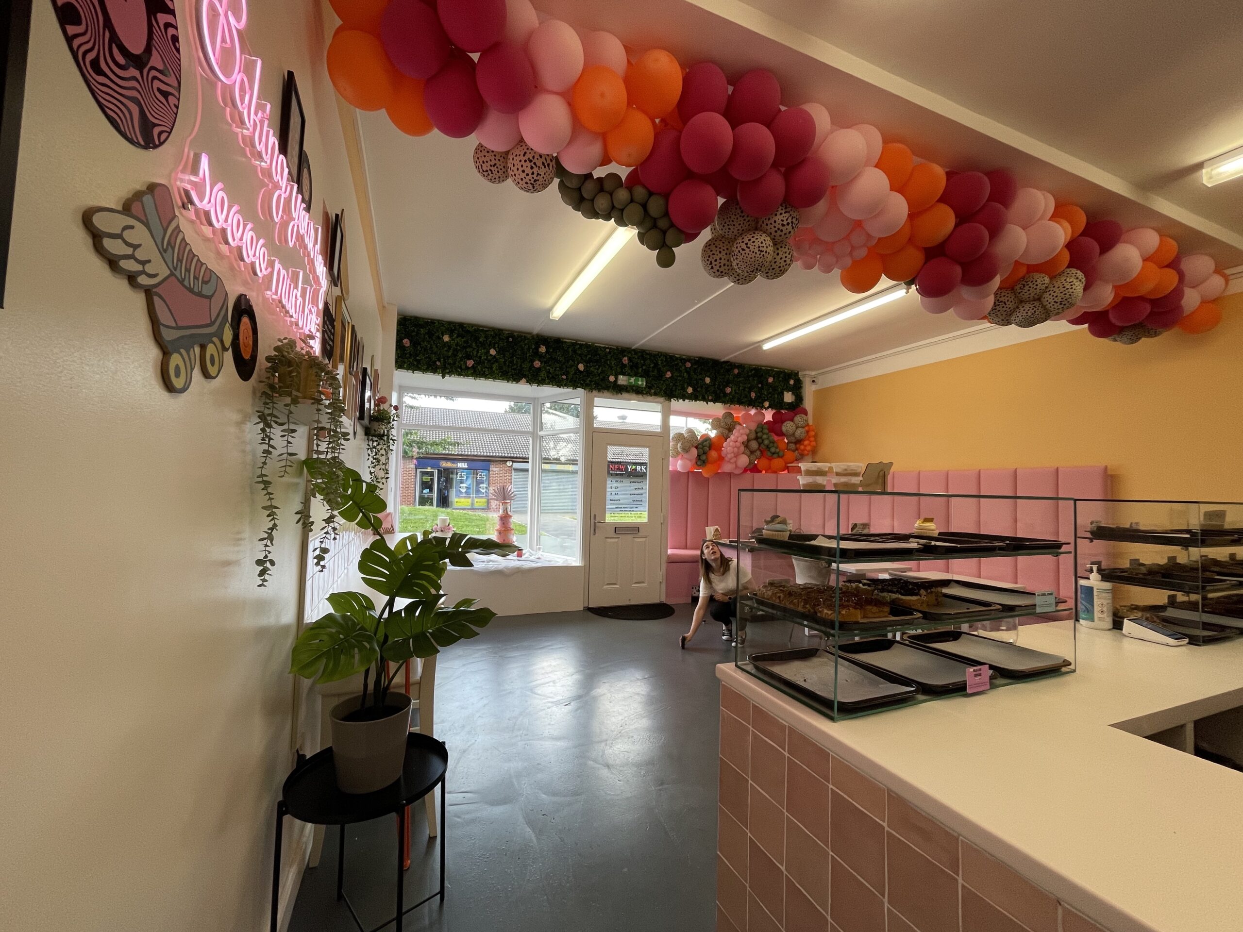The bakery in Doncaster before the redesign, with a balloon arch over the counter and a pink tiled servery