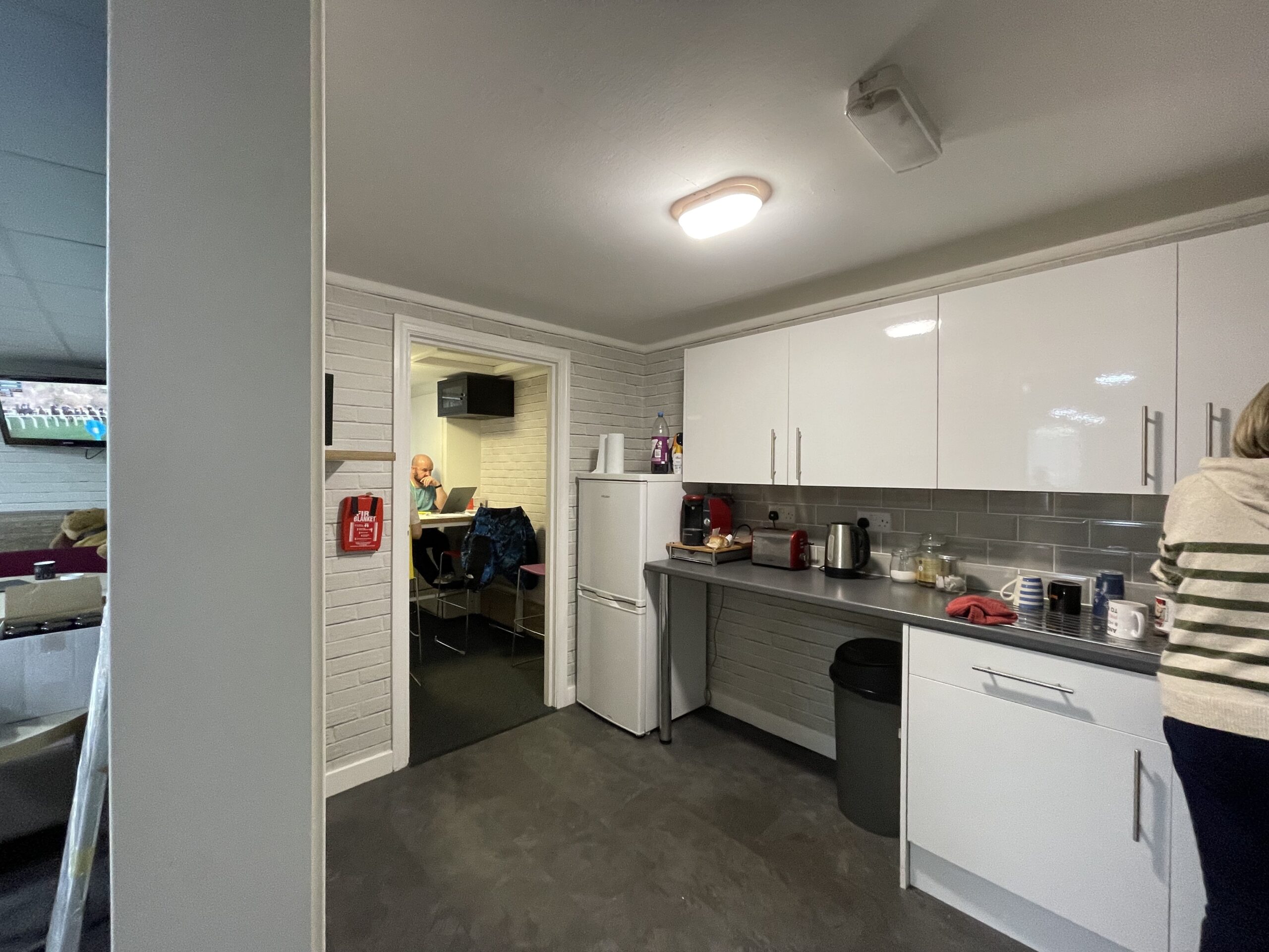 The staff kitchen at Gray and Sons before the redesign, with white units and a small worktop