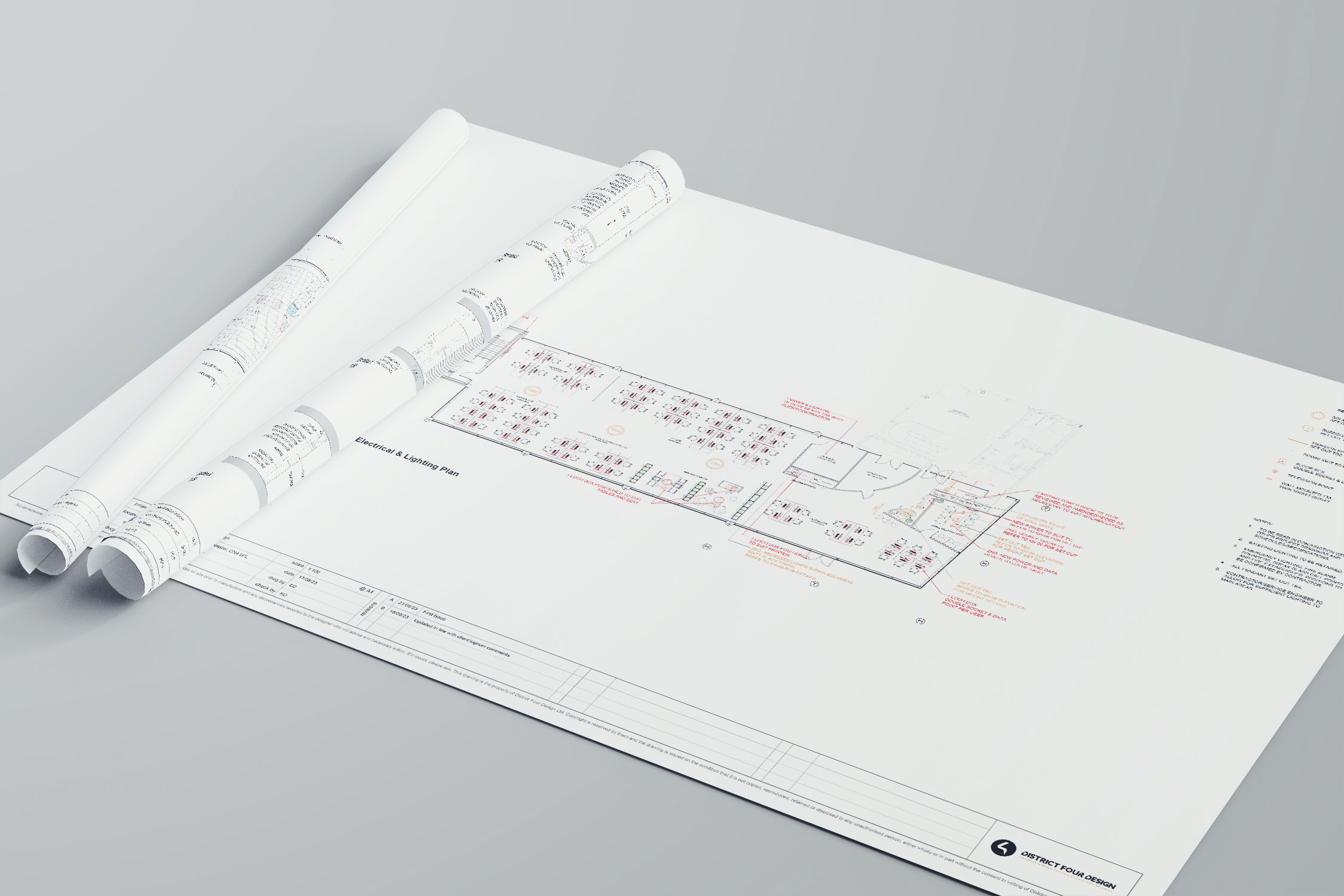 Rolled and flat space planning drawings for an office layout, laid out on a desk