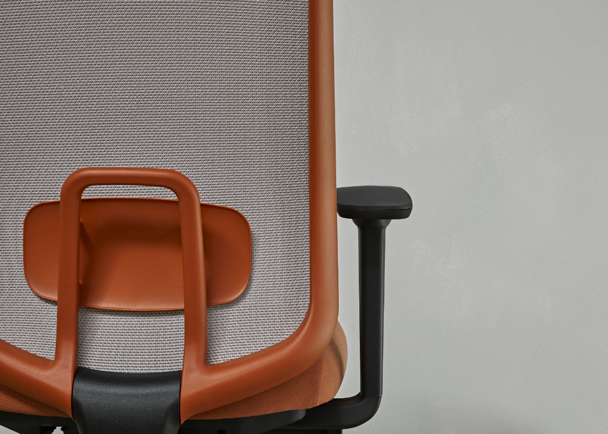 A close view of the back of an orange and grey task chair, showing the frame and arm