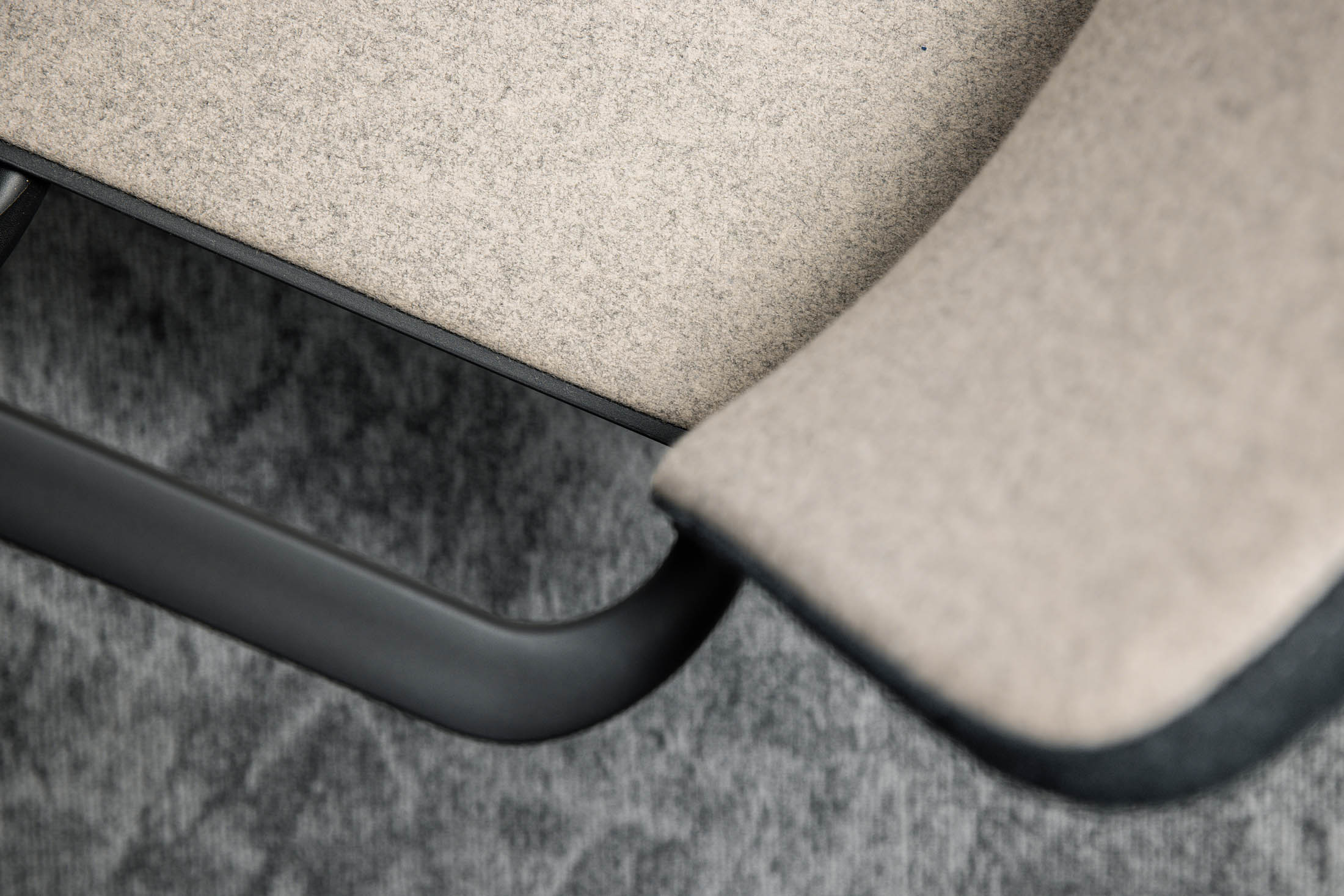 Modern showroom interior with Jotun product displays showcasing steel protection systems and coatings, featuring sample panels, branded literature, and a round meeting table with four upholstered chairs.
