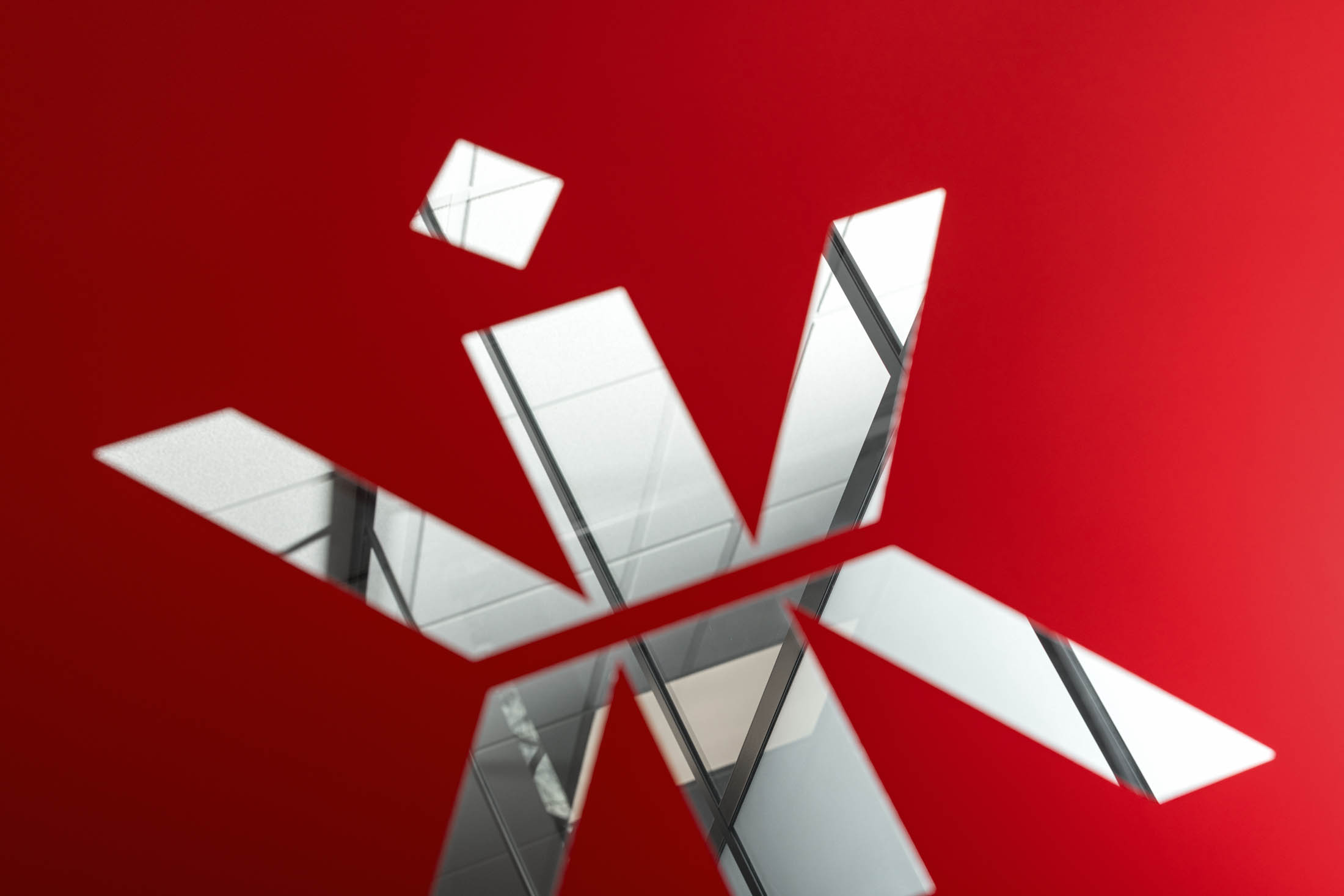 The Kingswood logo built as a mirrored dimensional sign on a deep red wall