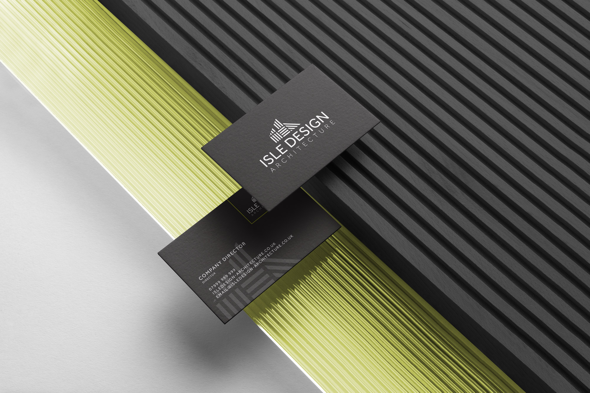 Isle Design business cards on a ribbed black and lime green surface