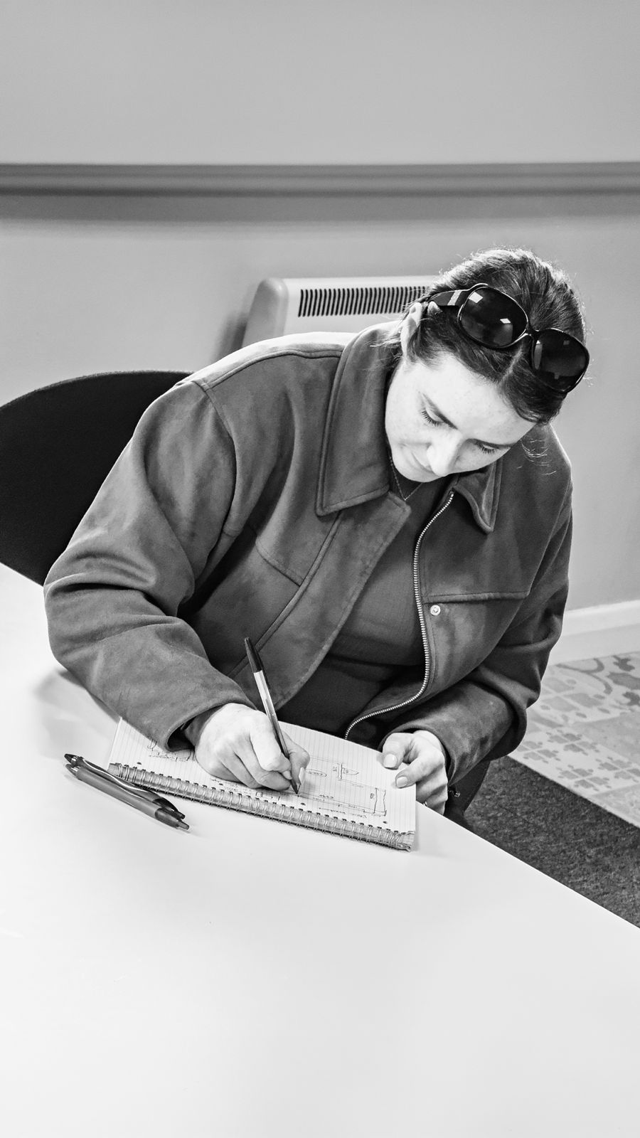 A designer sketching a layout at a desk