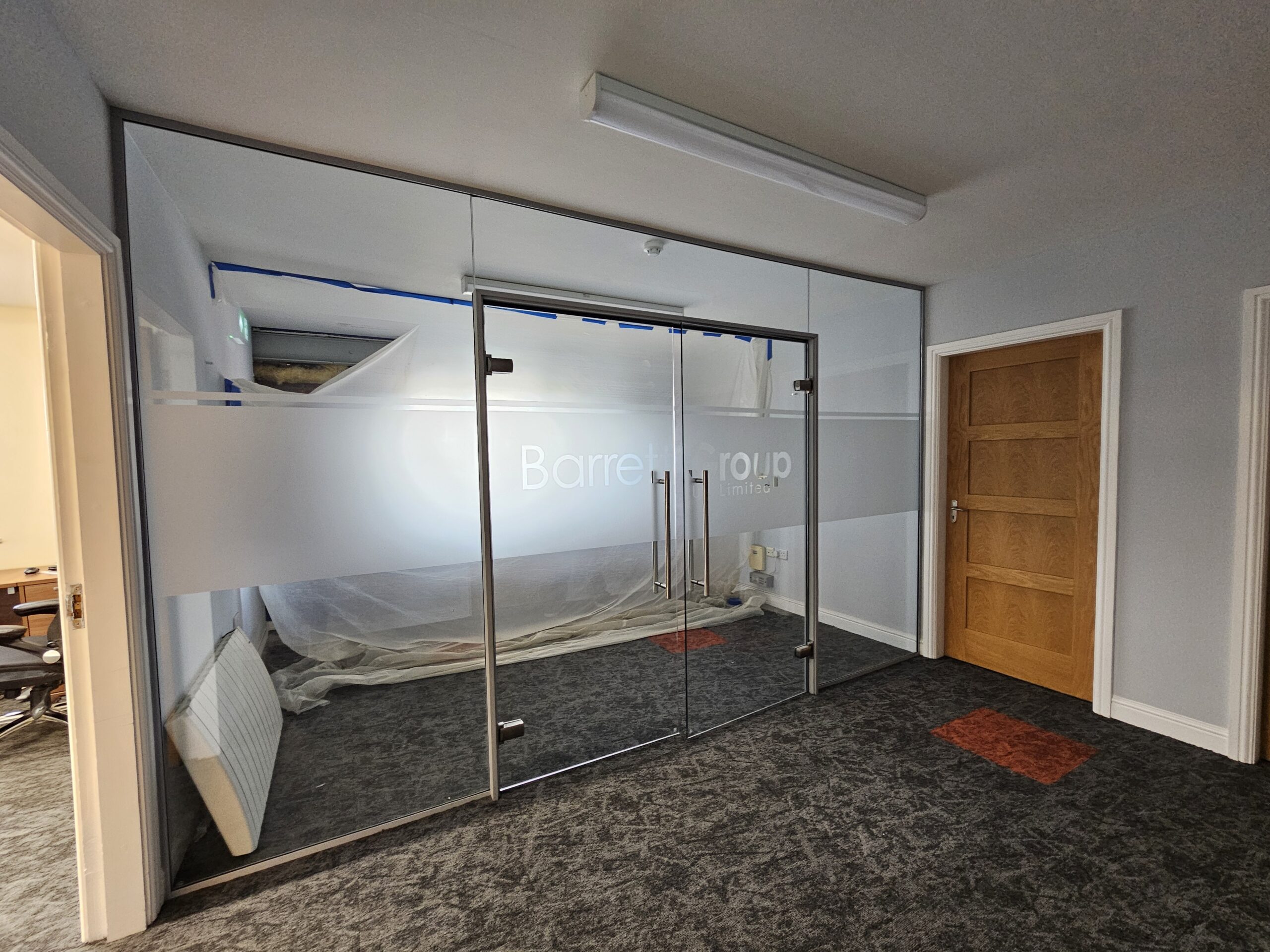 A glazed partition with Barrett Group frosting, during the works
