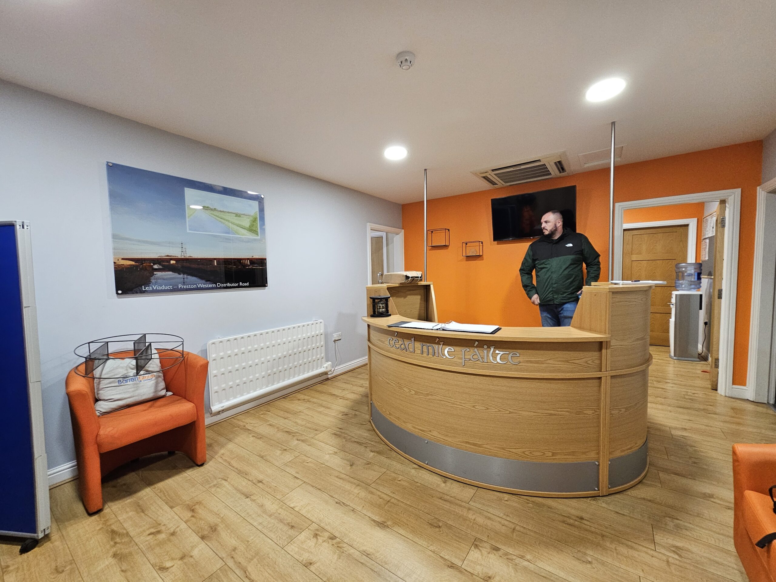 The old reception, with a curved timber desk, before the refurbishment