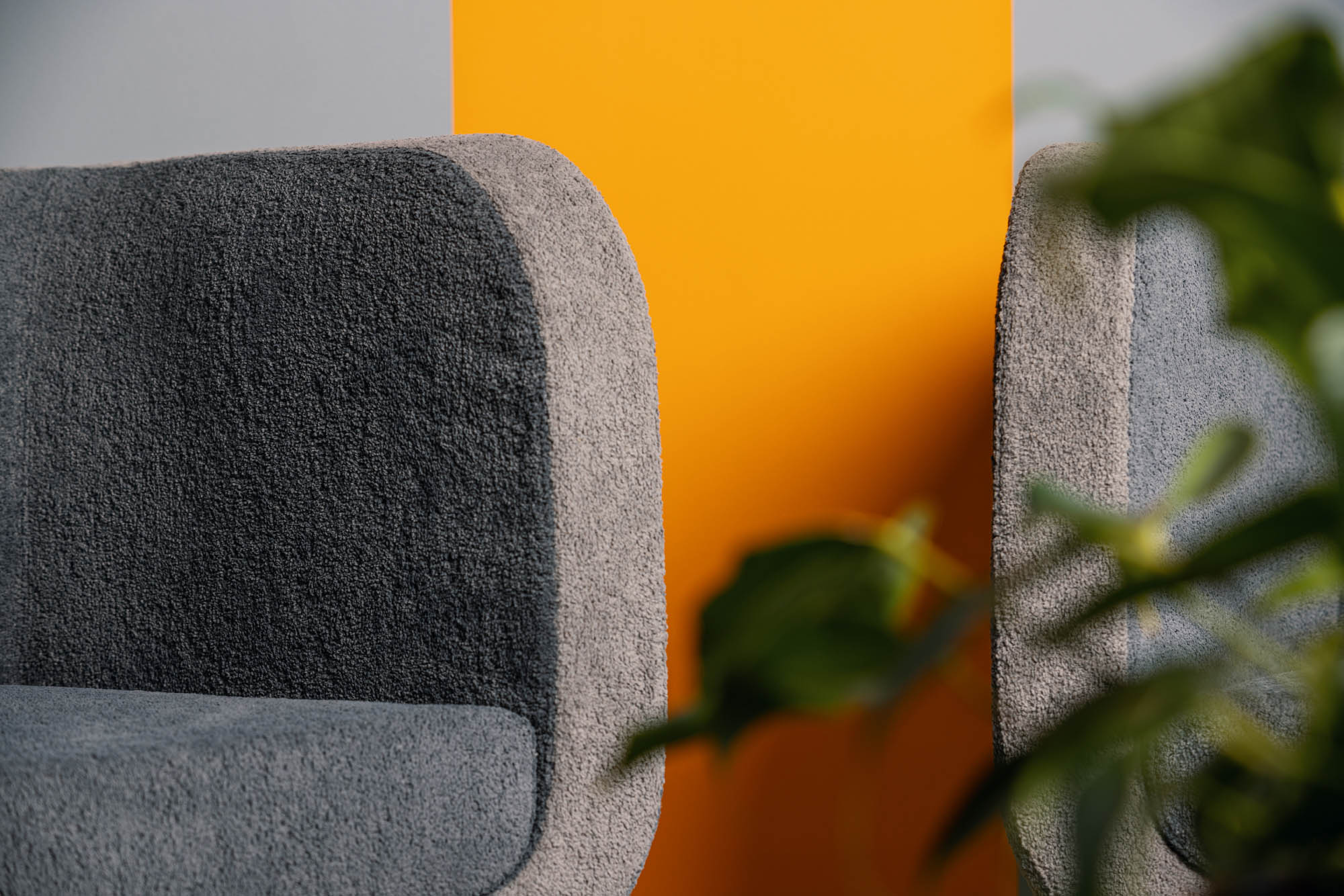 Grey high back seating against the orange feature wall