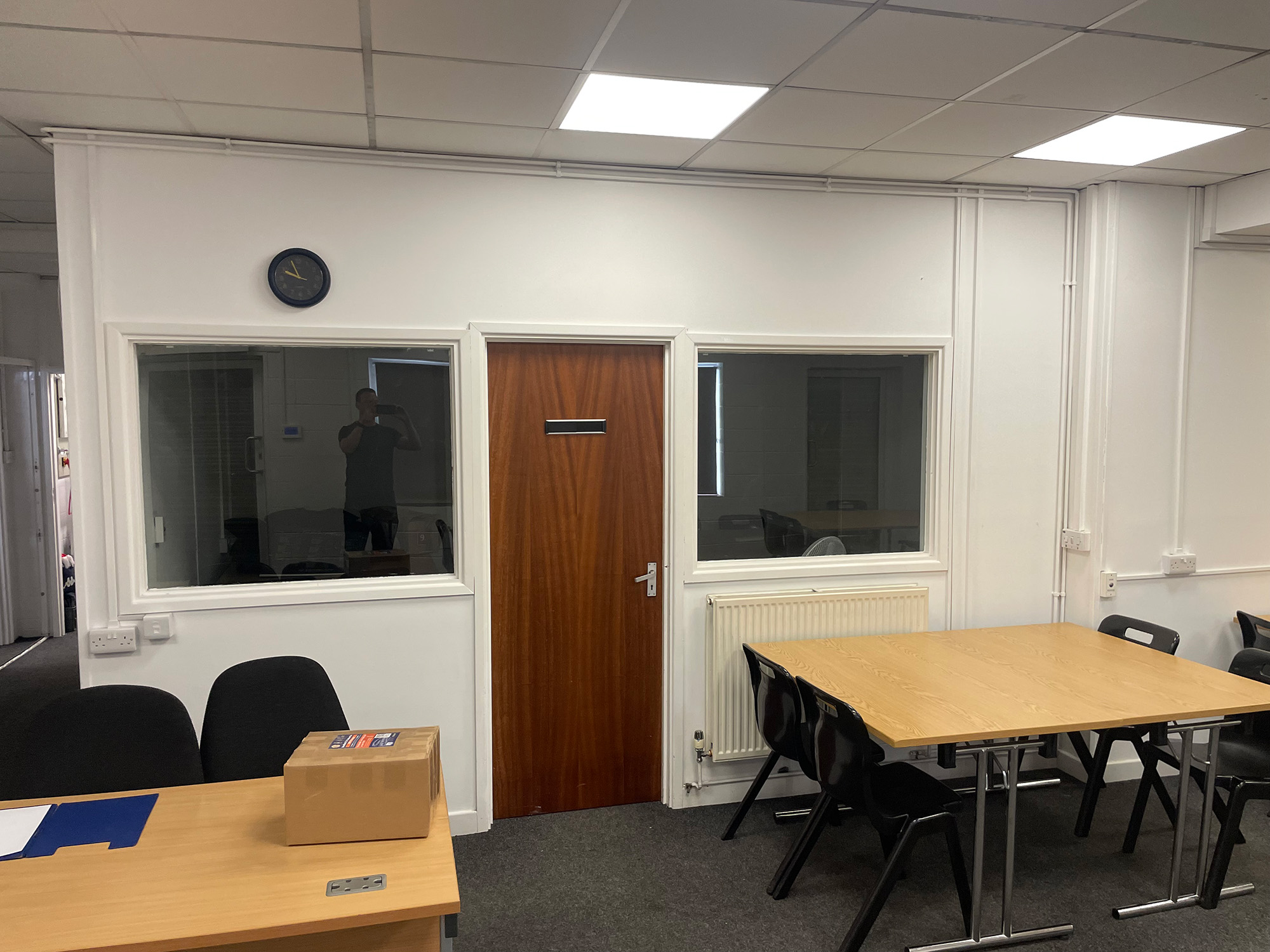 The original room before the redesign, showing a wooden door between two internal windows and folding tables